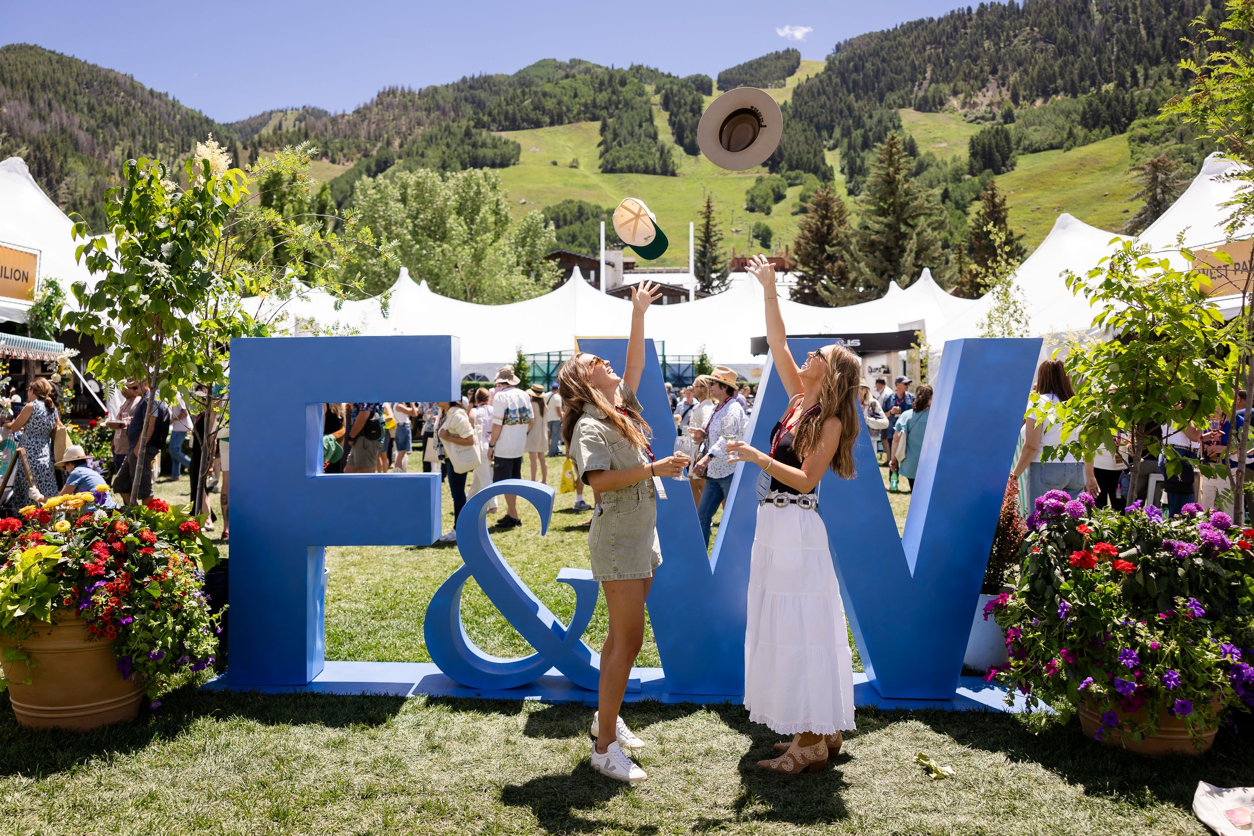 Outdoor food festival signage with mountain landscape in background.