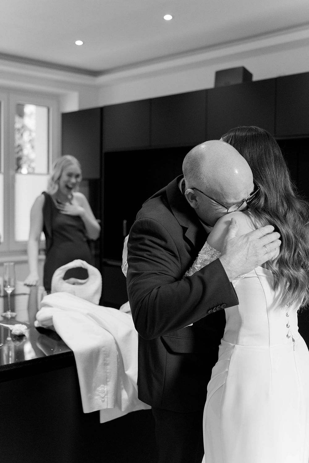 Black and white photos capture emotional embraces during a formal event.