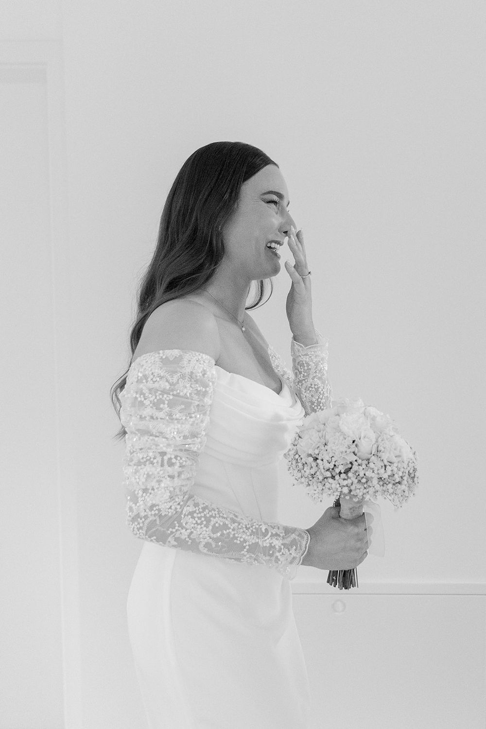 Candid black and white portrait of joyful laughter in a bright setting.