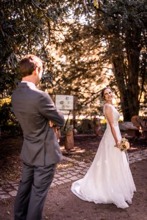 Wedding first look moment in garden setting during golden hour.
