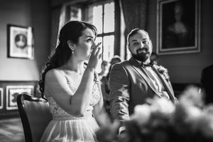 Candid black and white photograph capturing emotional wedding reception moment.