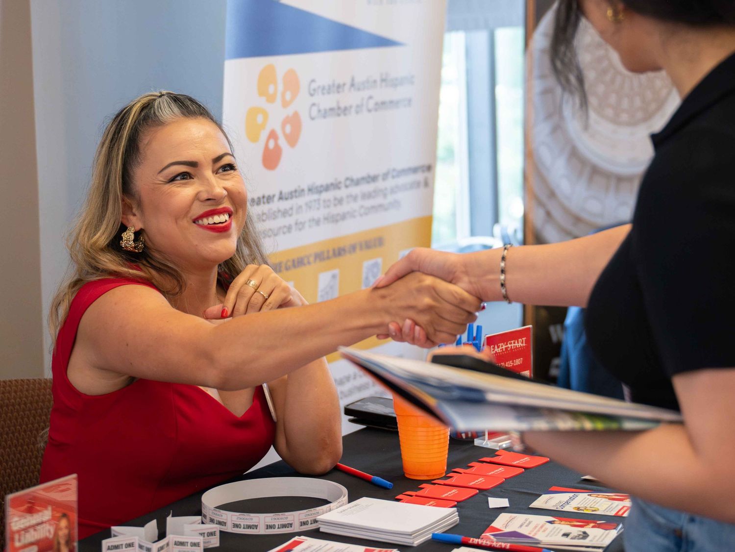 Sponsor shaking hands with attendee at business event, building credibility and gratitude.