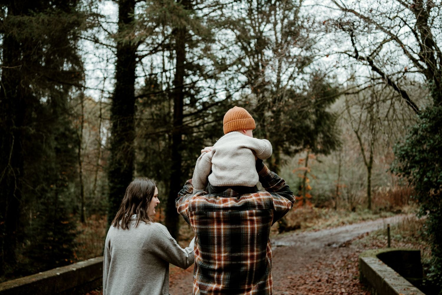 Family walking together through a misty forest path during autumn for photography