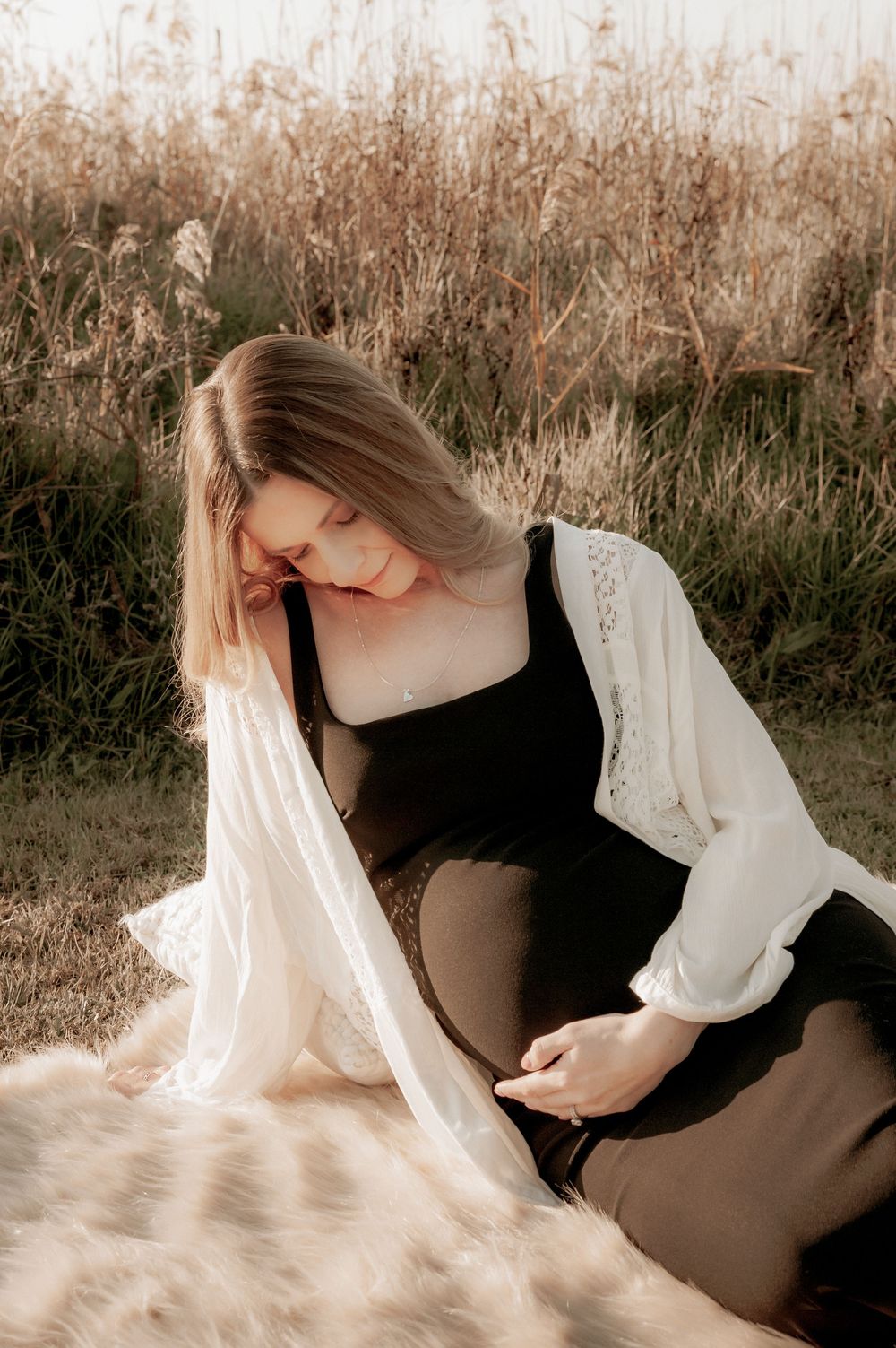 A maternity portrait in a field of tall grass with a person wearing a black dress and white cardigan.
Altona Family Photographer Melbourne