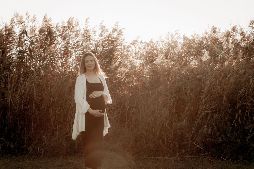 Pregnant woman in black dress standing among tall grass during sunset
.Altona Family Photographer Melbourne