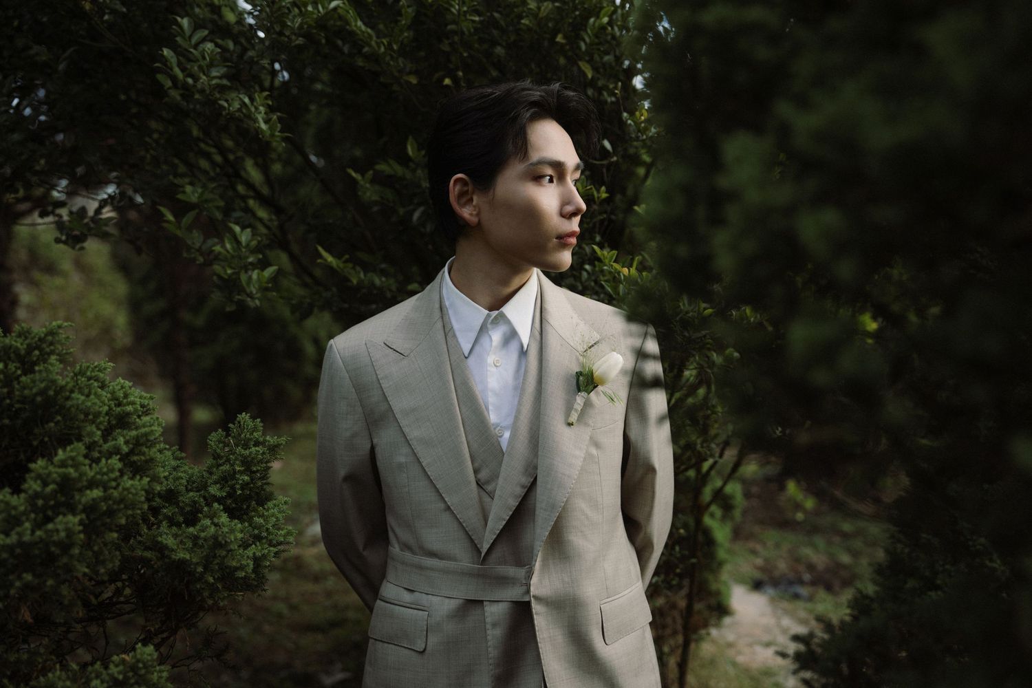 Fashion photography in a natural outdoor setting with dramatic lighting.