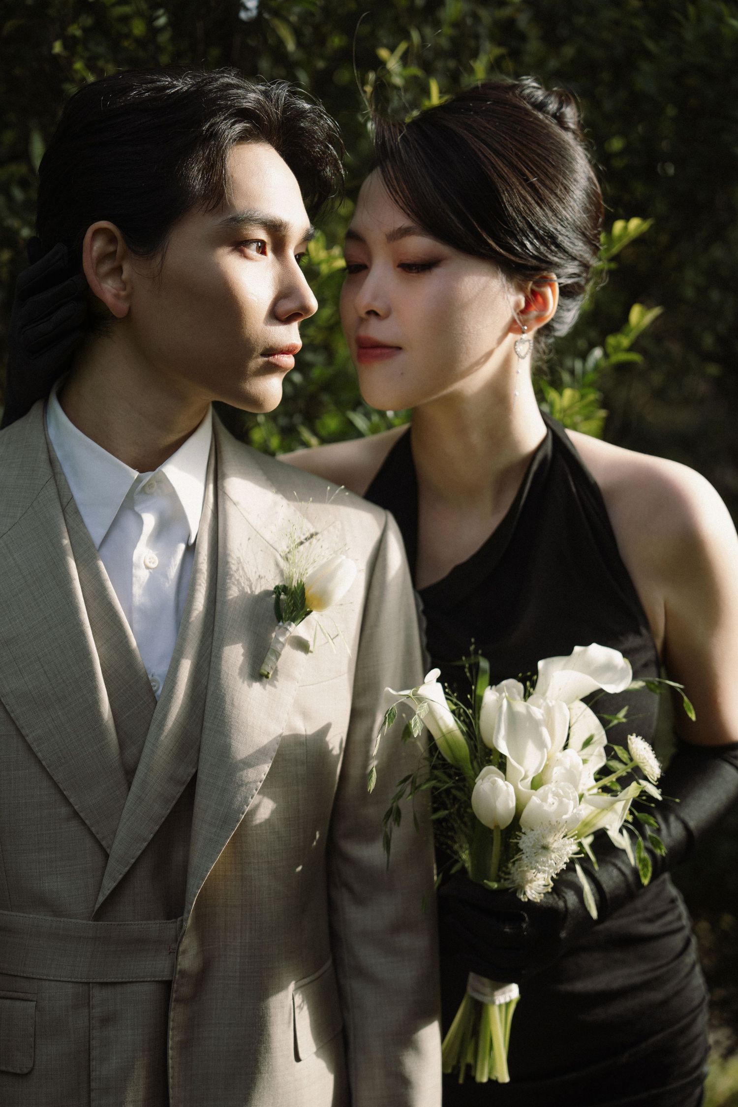 Intimate wedding portraits with white roses against a backdrop of garden foliage.