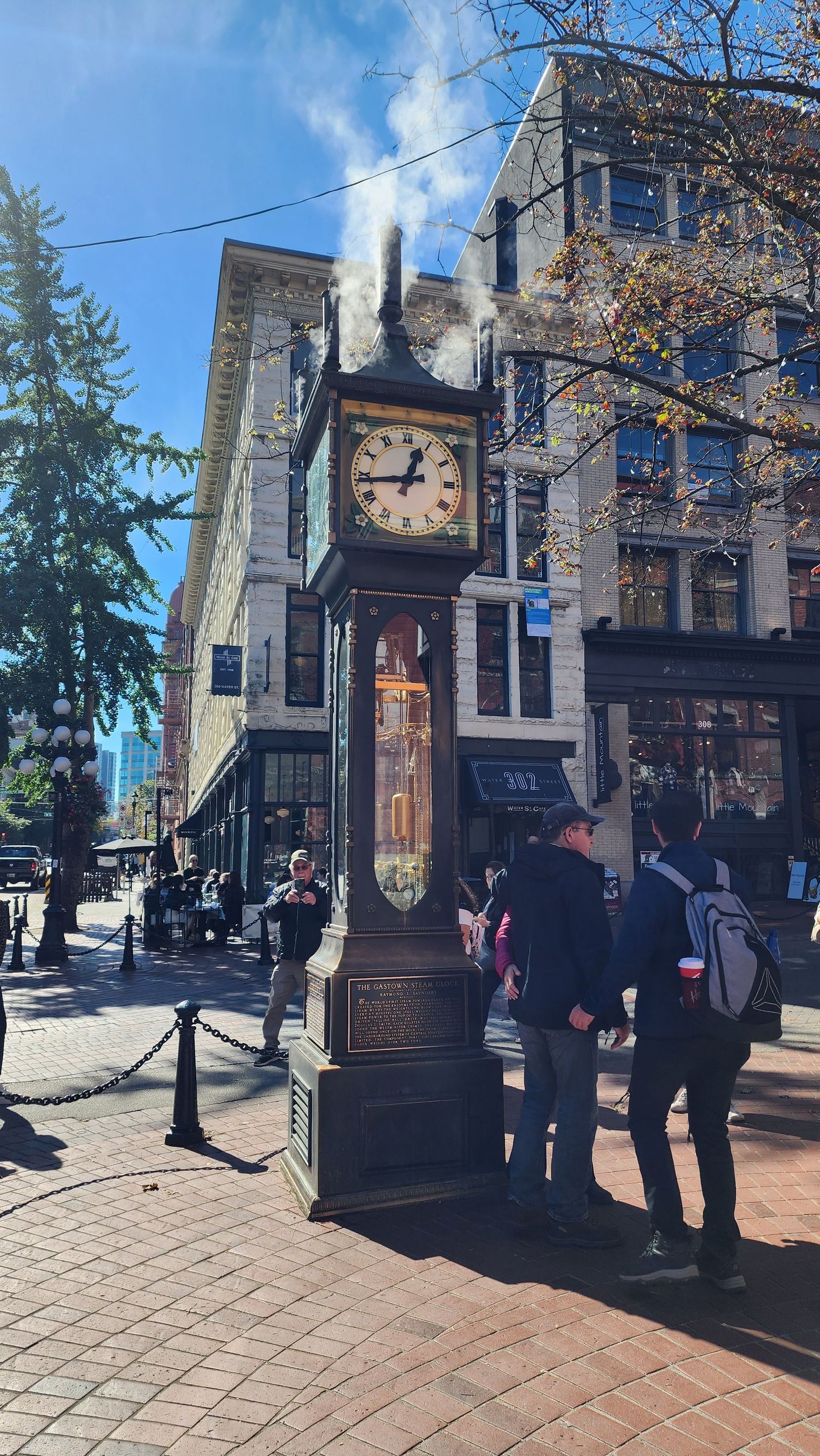Historic Gastown Steam Clock in Vancouver surrounded by visitors on a sunny day.