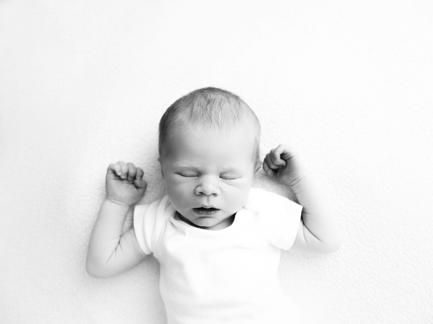Photographic series showing a baby's sleeping face from different angles in black and white.