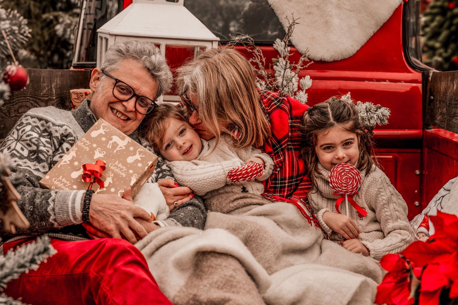 A winter photo series featuring cozy plaid blankets, red holiday decor, and intimate moments in warm neutral tones.