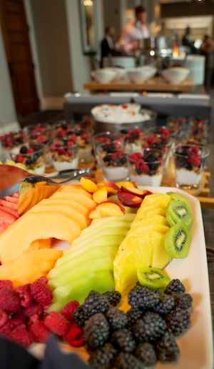 Fresh fruit platter with colorful berries, kiwi, and tropical fruits arranged decoratively.