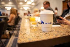 Marble countertop with coffee cups and refreshments at a corporate event.