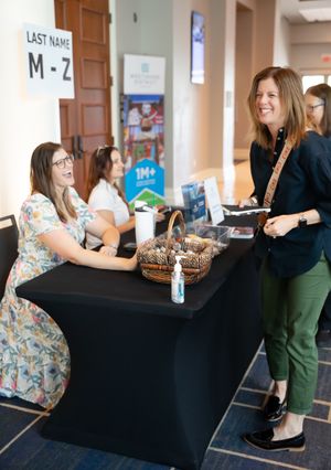 Event check-in station with black tablecloth and registration materials.