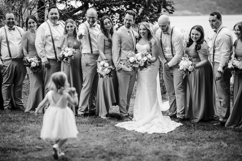 Black and white candid wedding party photos showing joyful outdoor celebration moments.