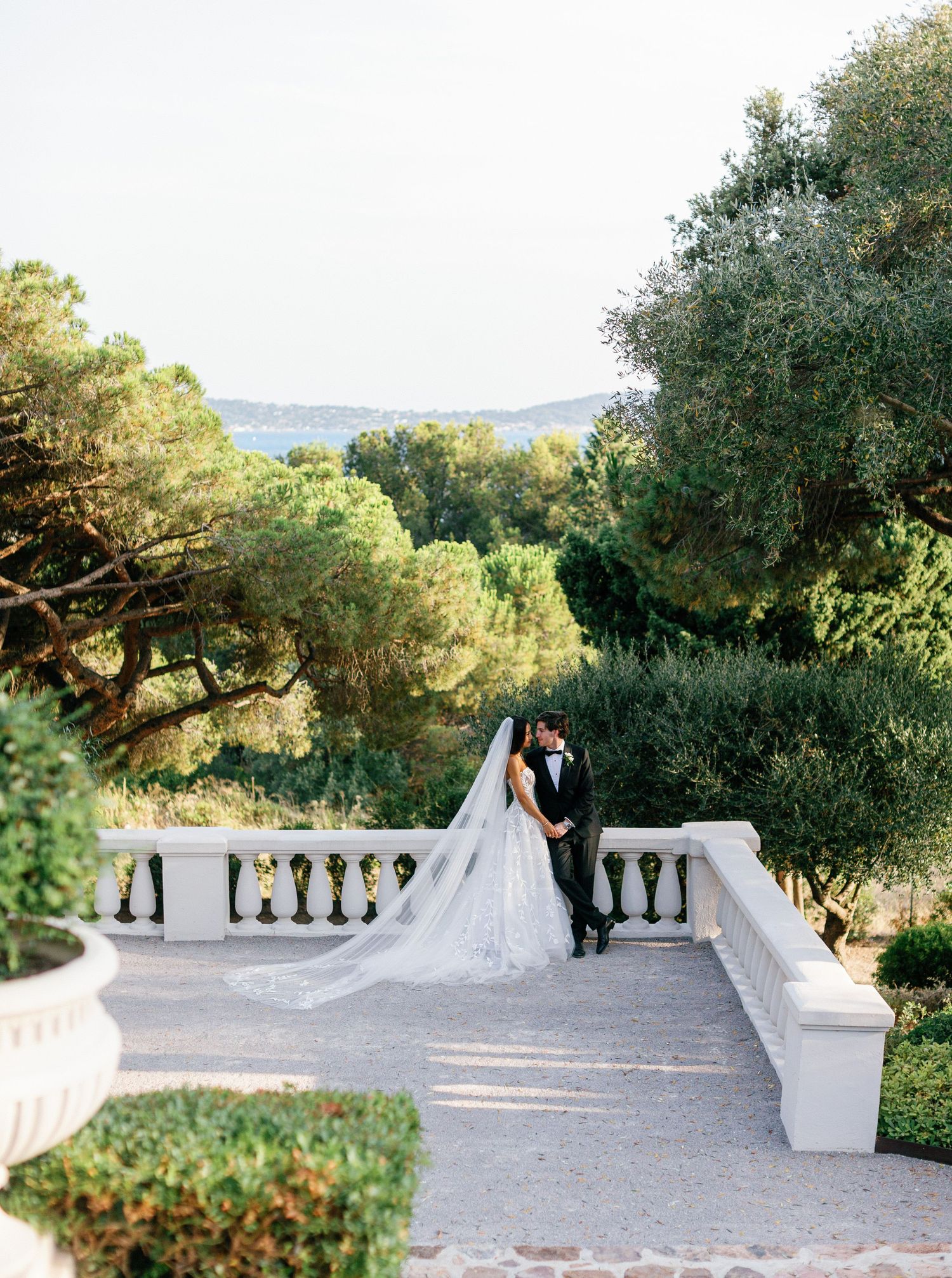 Wedding couple shares romantic moments on a beautiful stone terrace surrounded by lush Mediterranean gardens.