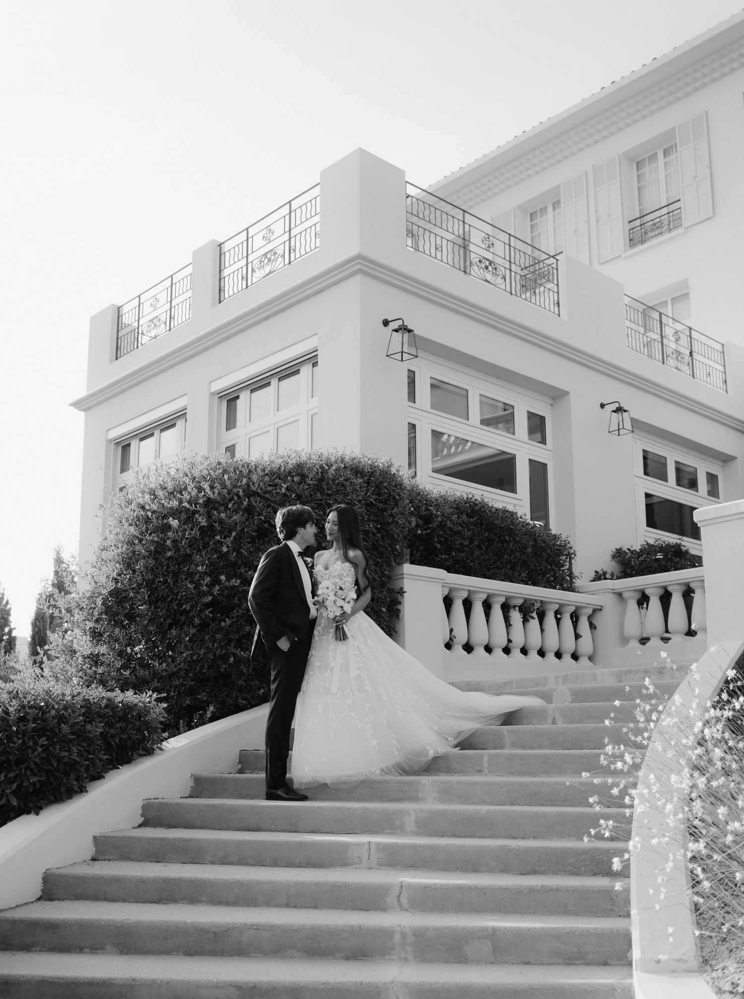 Black and white photo sequence shows couple on vintage mansion steps in a romantic photoshoot moment.