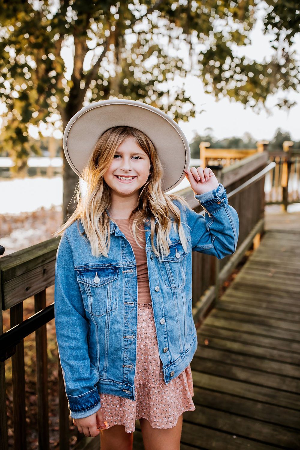 Four connected photos show a beige hat and denim jacket against a wooden boardwalk with trees in the background.