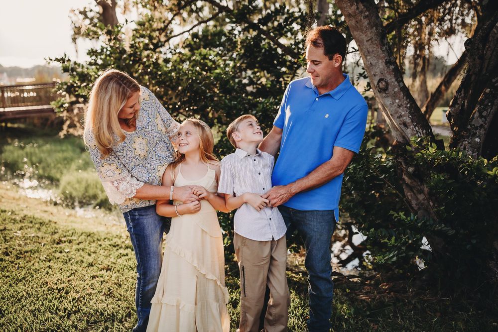 Family enjoying a candid outdoor photoshoot together in a golden sunlit field.