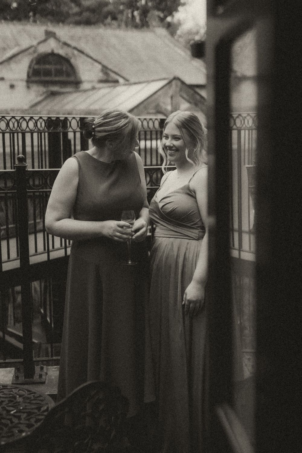 A series of four black and white photos showing people in formal attire standing on an outdoor deck or patio area.