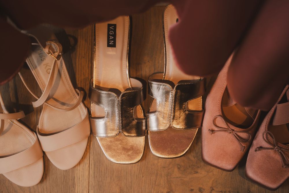 Row of classical dance shoes arranged on wooden floor showing different shades of pink and beige.