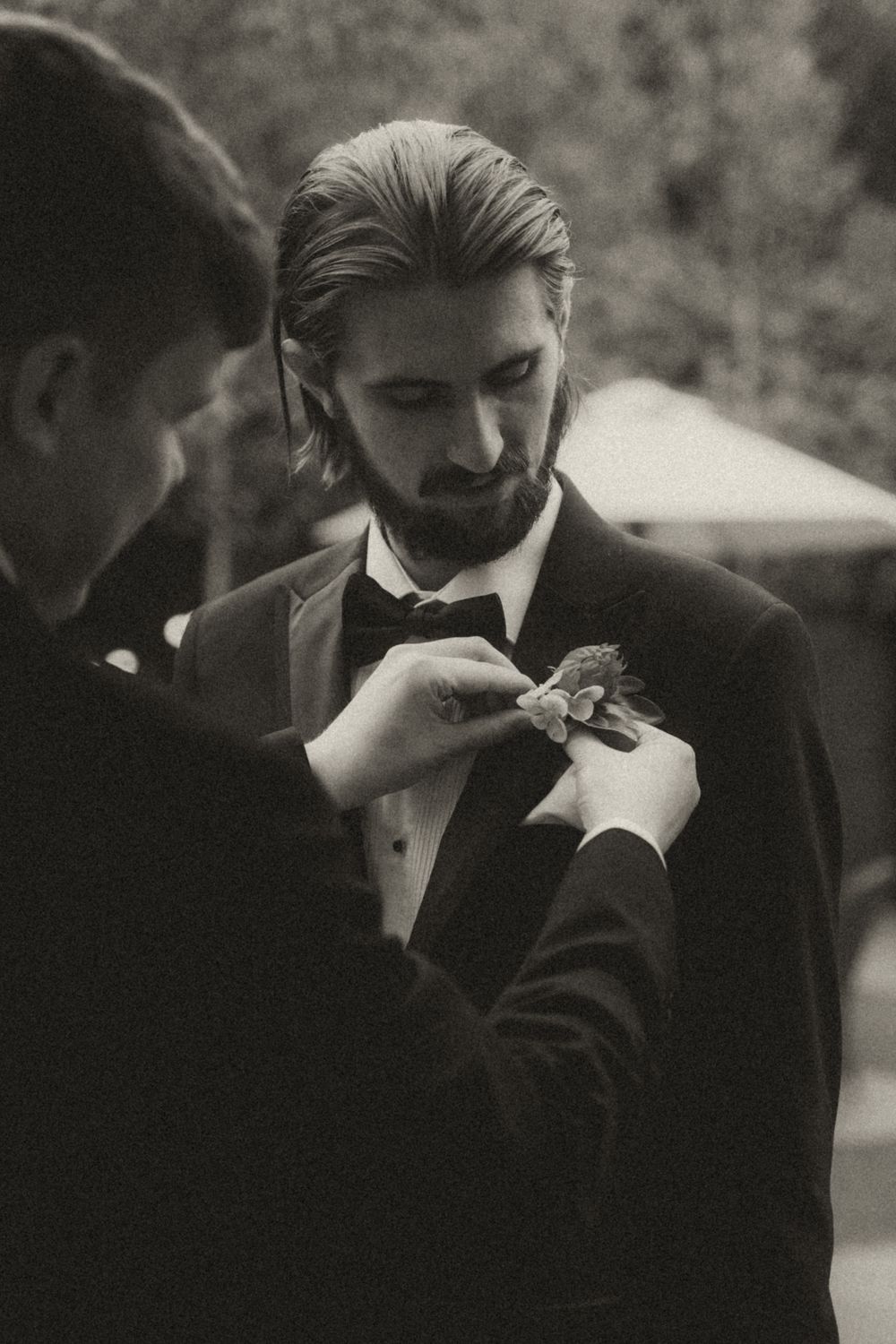 A candid black and white photo sequence showing a person in formal attire lighting a cigarette.