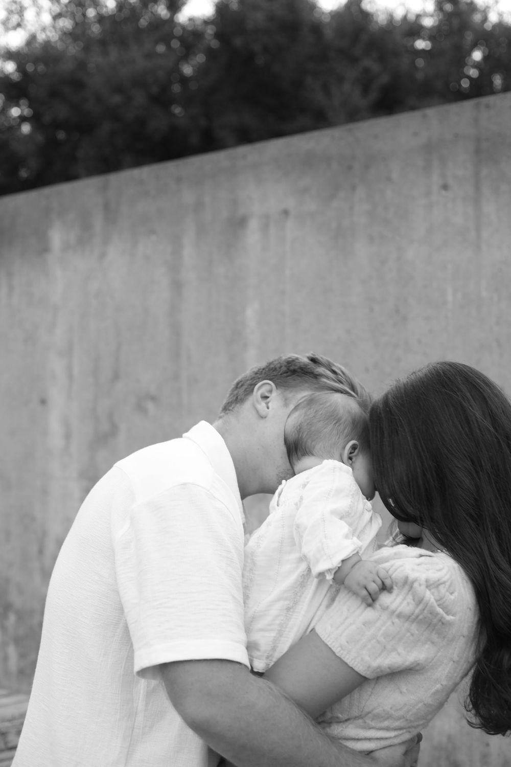 Black and white intimate family portraits capturing tender moments outdoors.