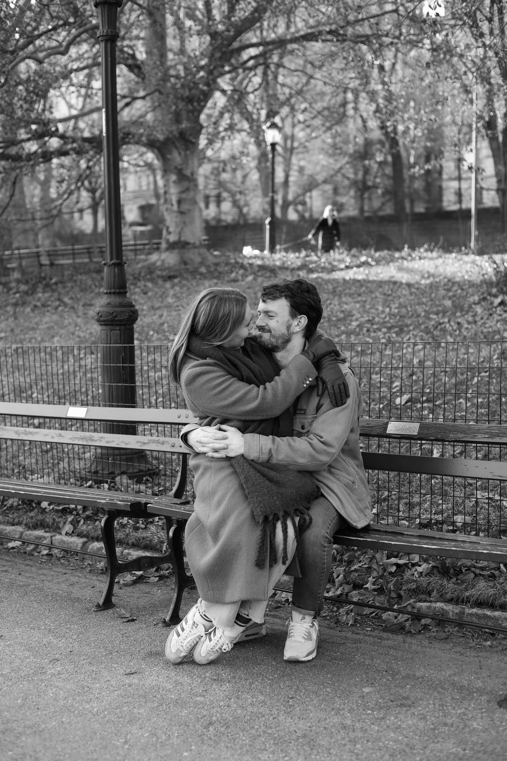 Black and white photo series of couple sharing tender moments on a park bench.