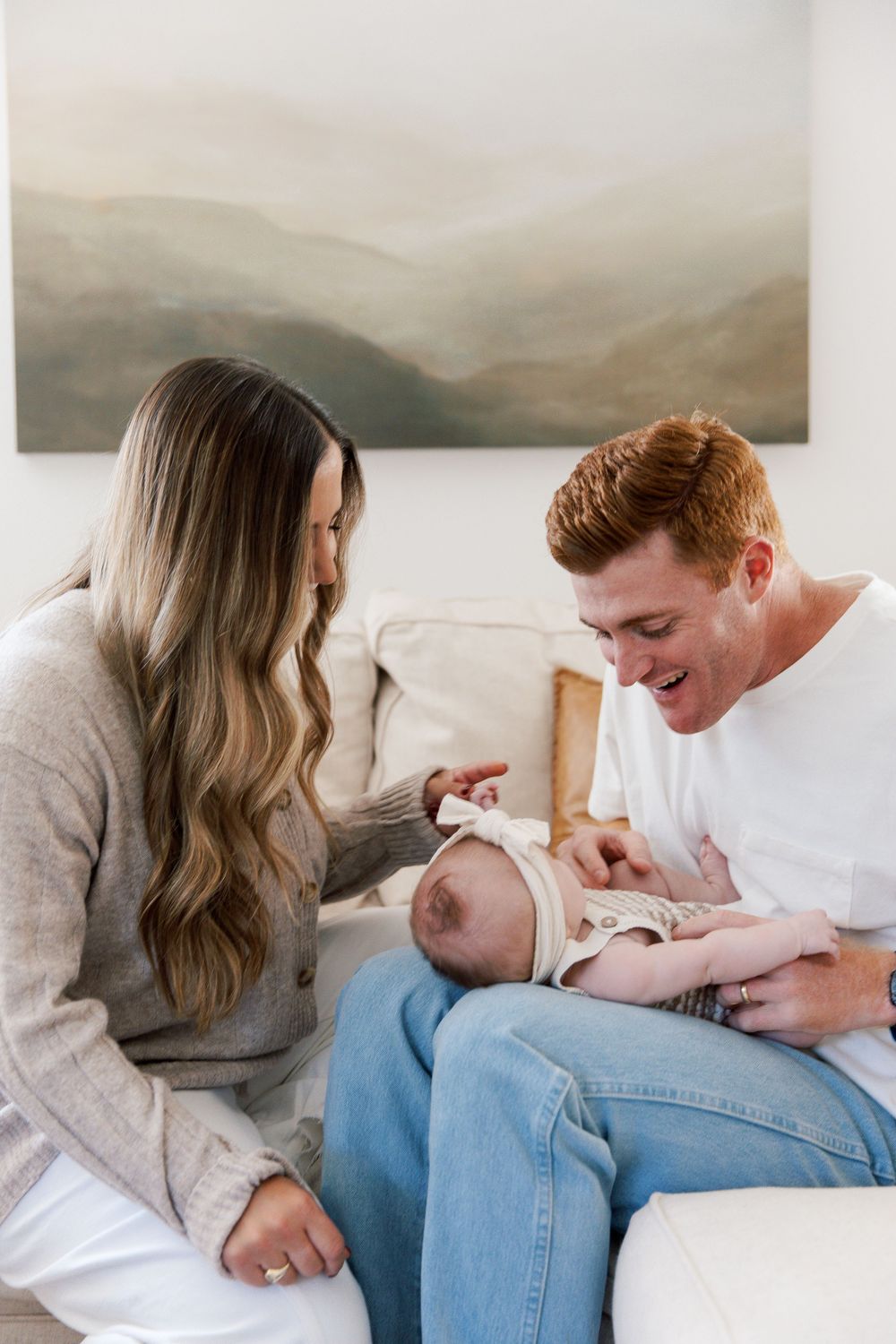 Tender family moments captured in sequence on white couch with neutral decor.