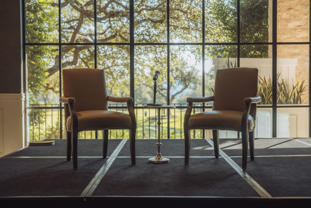 Large windows overlooking trees in an elegant conference or event space.