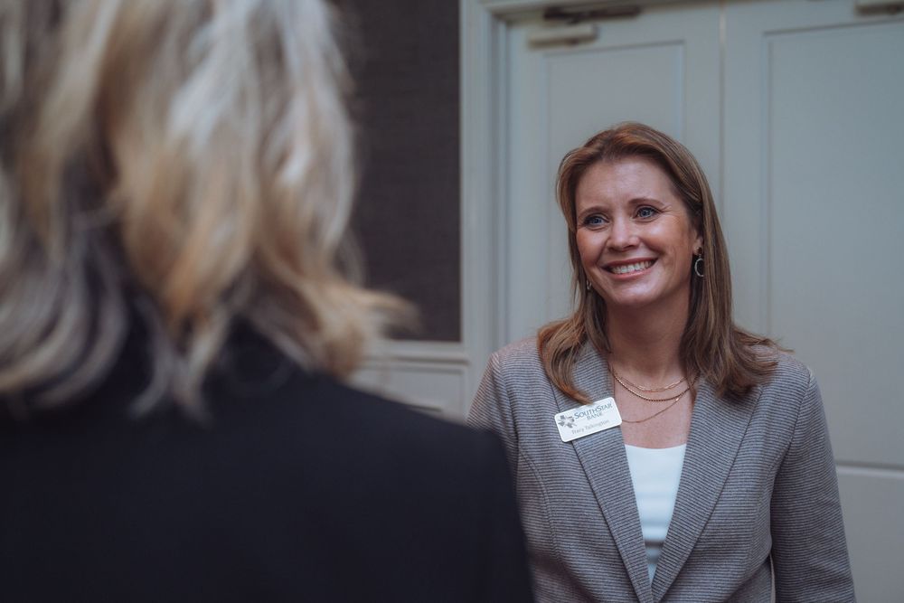 Two professionals engaged in conversation at a business networking event.