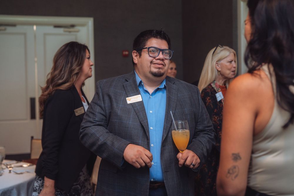 Business professionals socializing at a networking event with drinks.