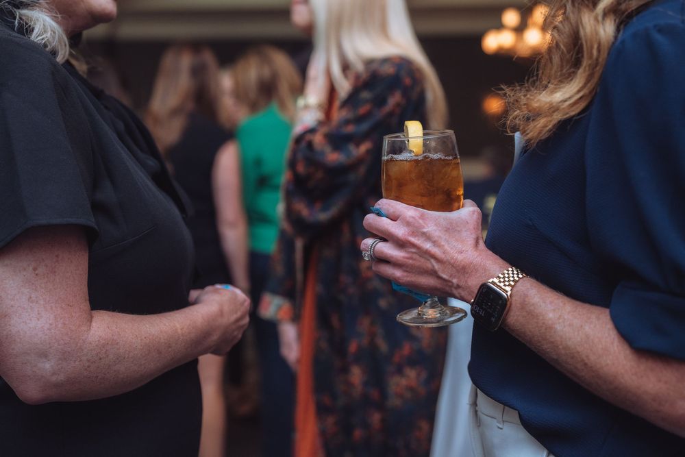 Close-up of people holding drinks during a networking event.