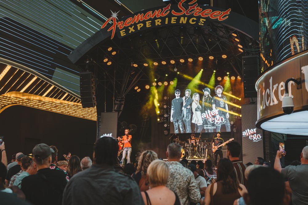 Concert venue with colorful stage lighting and crowd silhouettes during live performance.