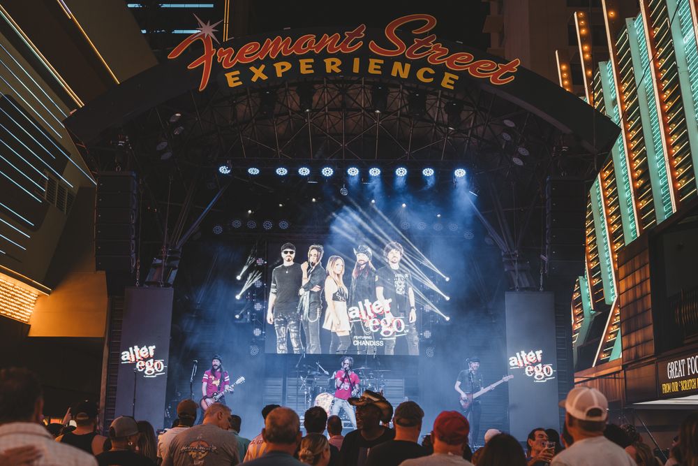 Concert stage with large video screens and theatrical lighting during live entertainment show.