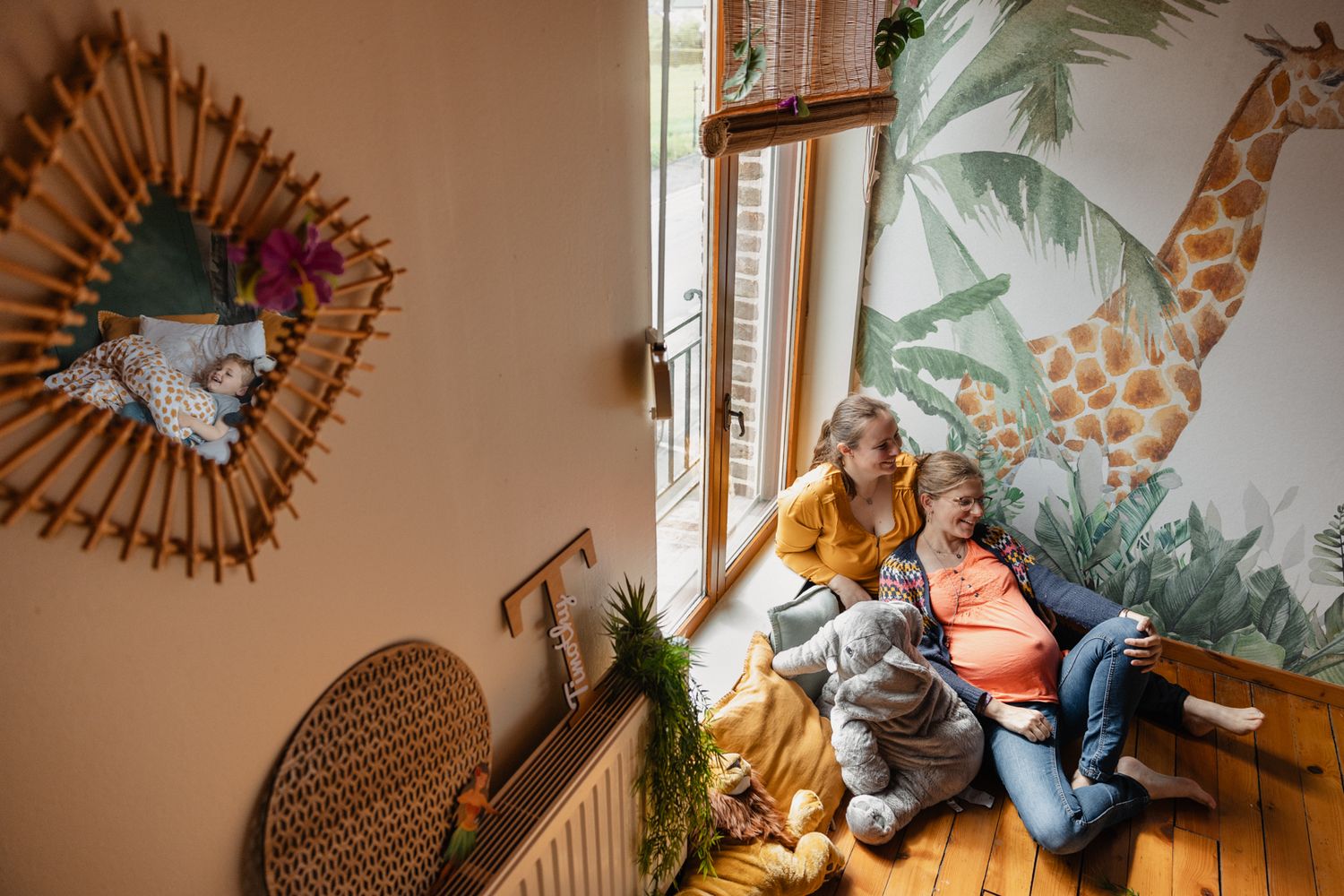seance photo pour un couple de femme attendant leur deuxieme enfant et vivant un moment de complicite avec leur fils aine