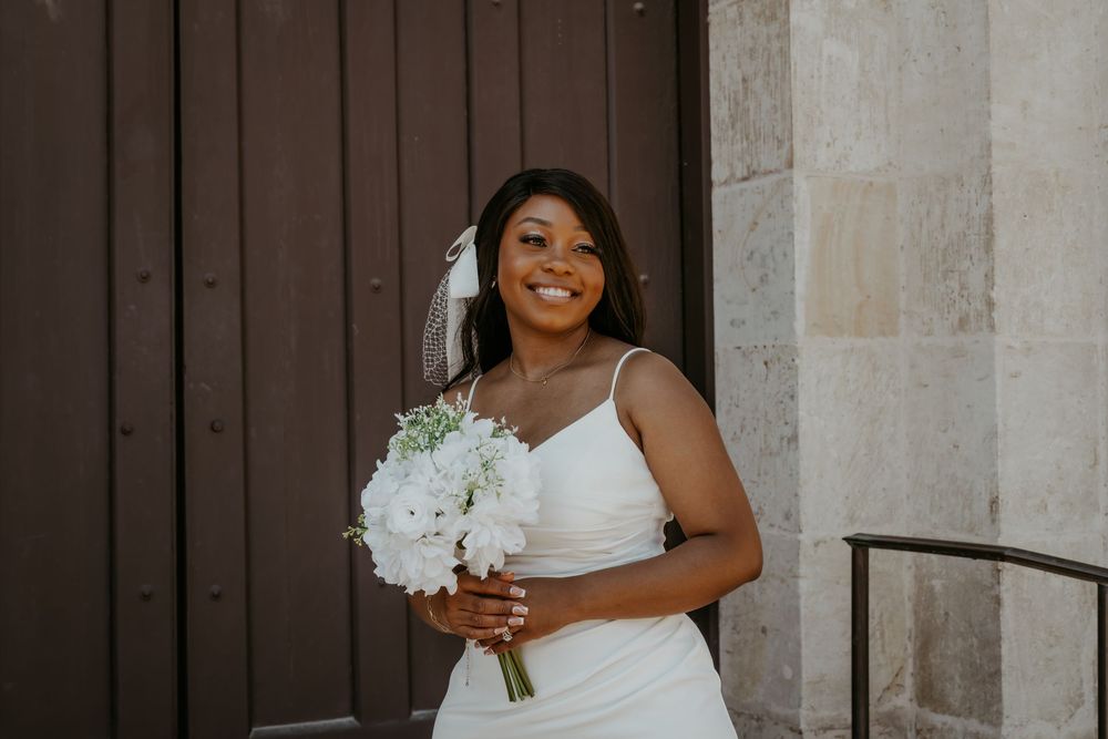 A joyful wedding moment captured against architectural stone columns.