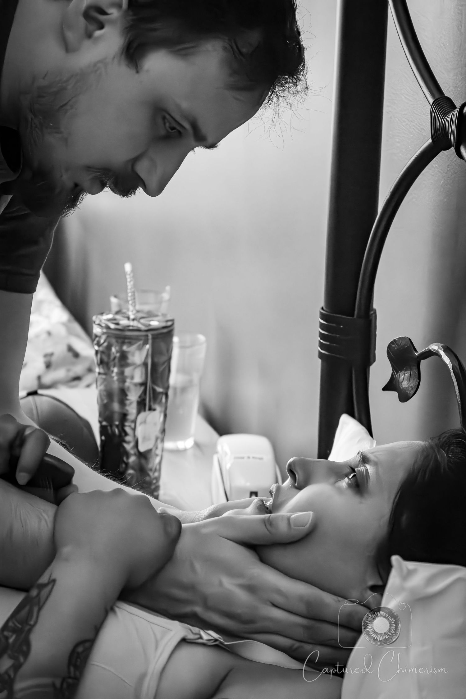Artistic black and white shot of a couple sharing an intimate moment during labor.