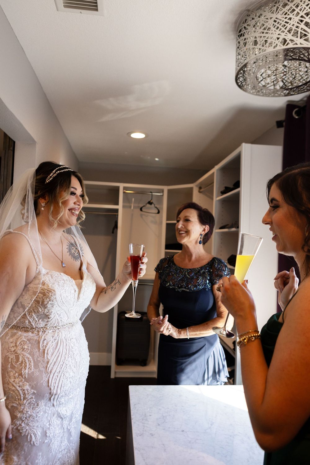 Bride with mother and bridesmaid toasting during getting ready photos at Las Vegas Airbnb