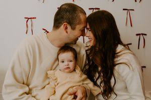 Intimate family photoshoot with everyone wearing matching cream sweaters.