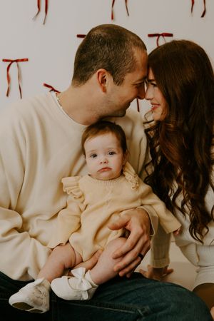 Sweet family moments captured in a minimalist studio setting with neutral tones.