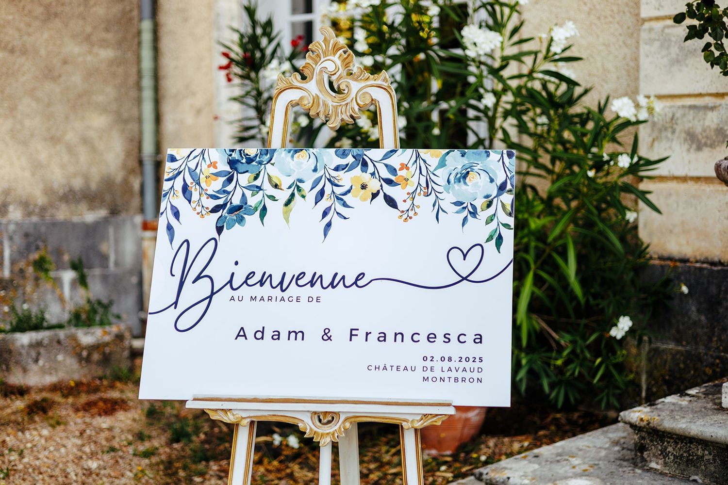 A row of elegant blue and white floral wedding welcome signs displayed outdoors against a rustic wall.