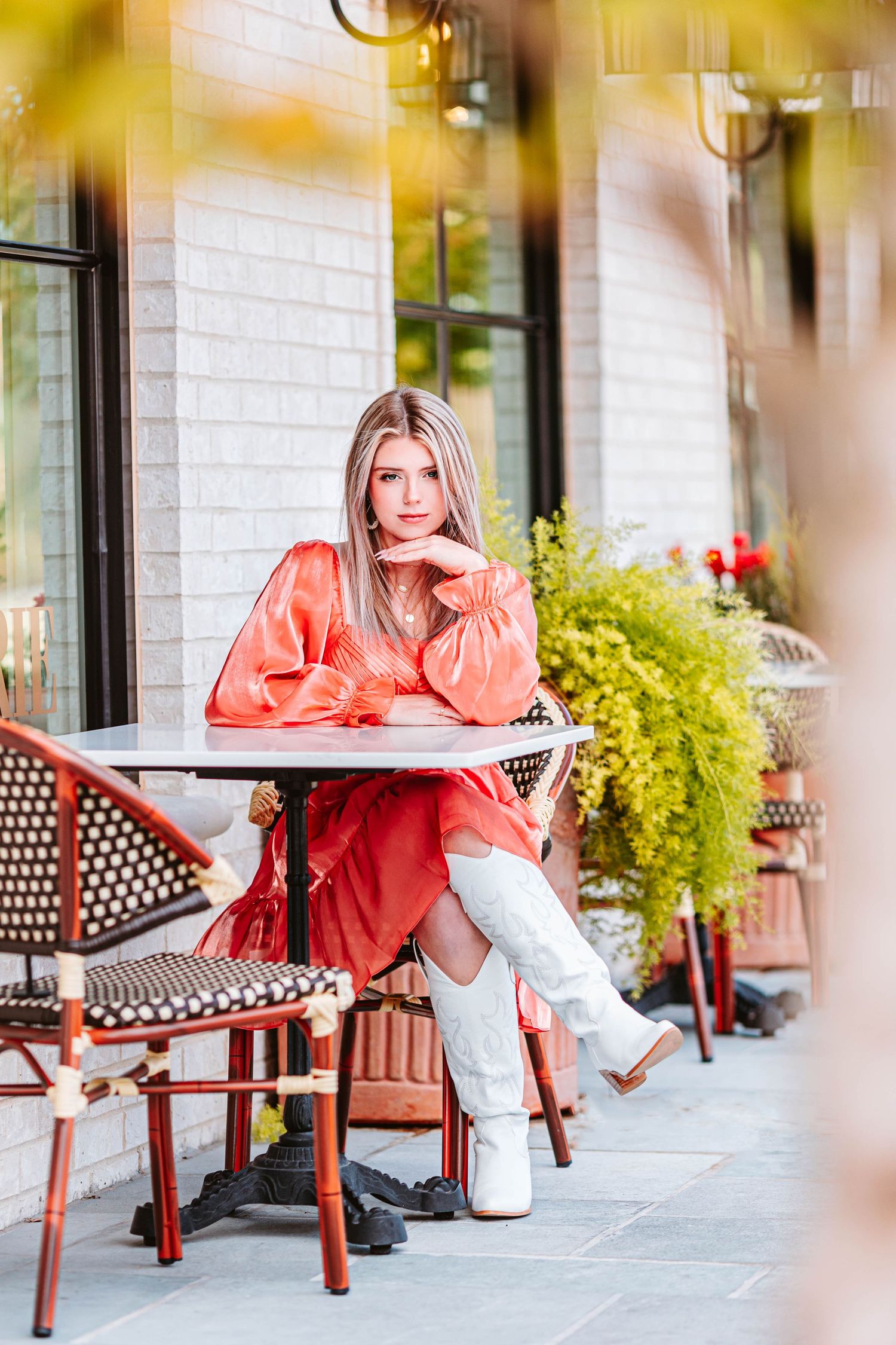 Casual portrait session on red metal bench against white brick wall with yellow accents.