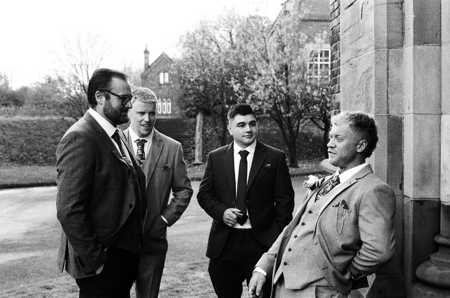 A series of black and white photographs showing people in suits having conversations outside a building.