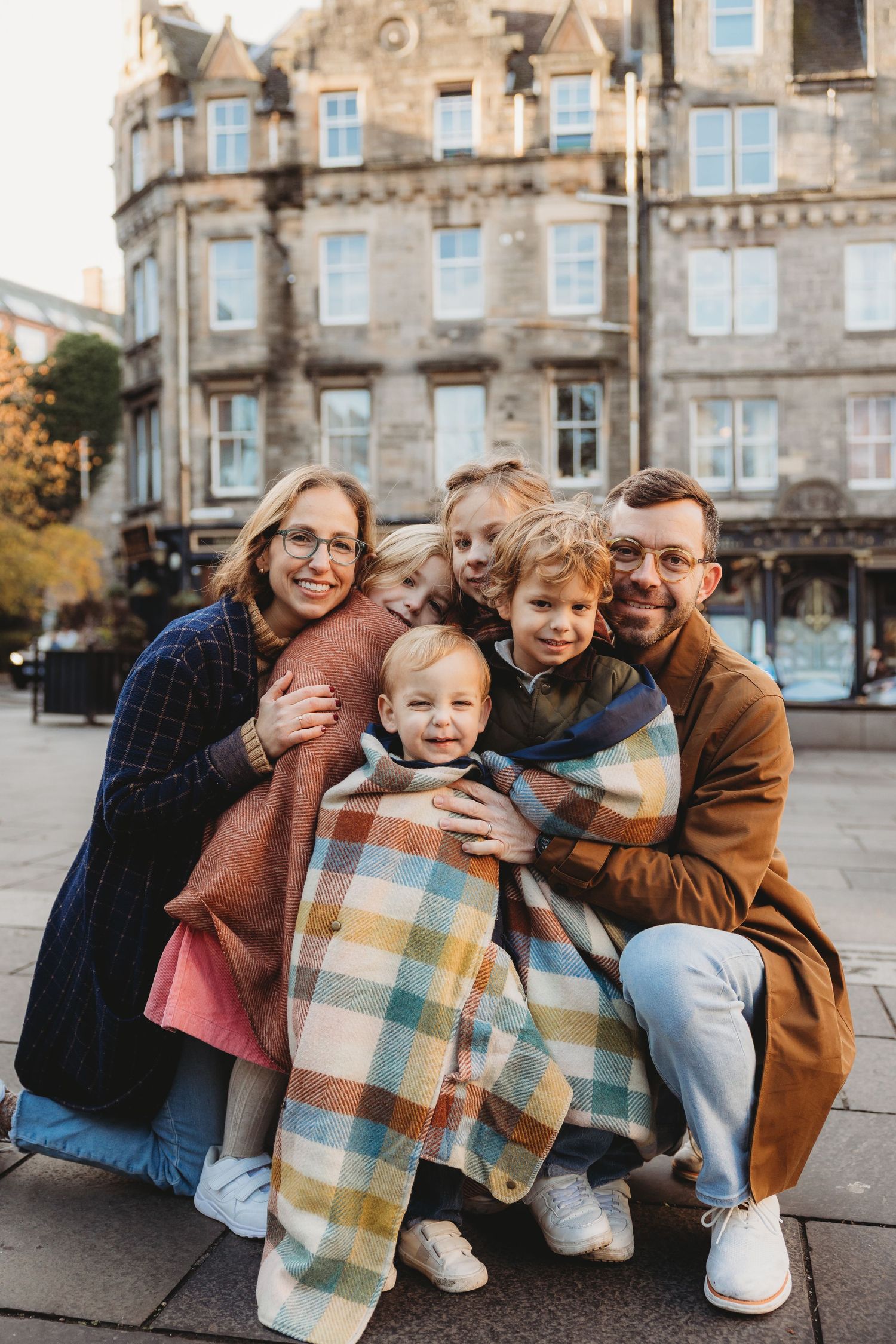 A candid family moment captured in five sequential photos showing playful interaction on a city street.