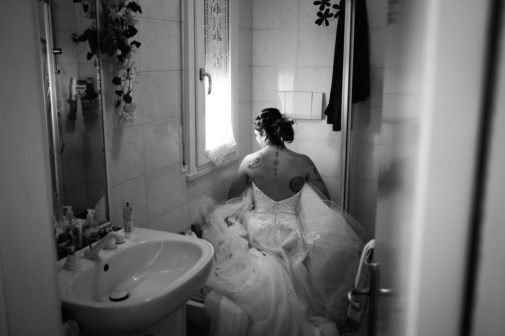 Black and white photo series showing someone bathing a dog in a bathroom tub.