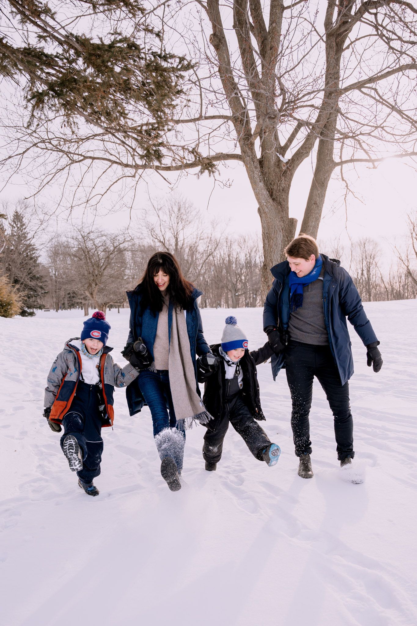 Seance photo de famille dans la neige en hiver au parc du Mont-Royal à Montreal.