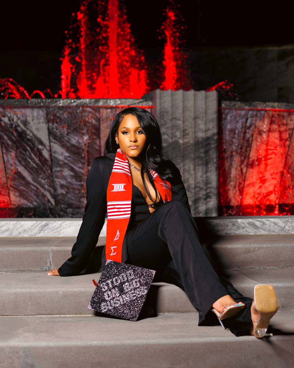 Fashion model poses against dark backdrop with dramatic red lighting in series of glamorous editorial shots.