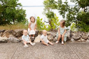 Family members sitting together on rocky terrain in a natural outdoor setting.