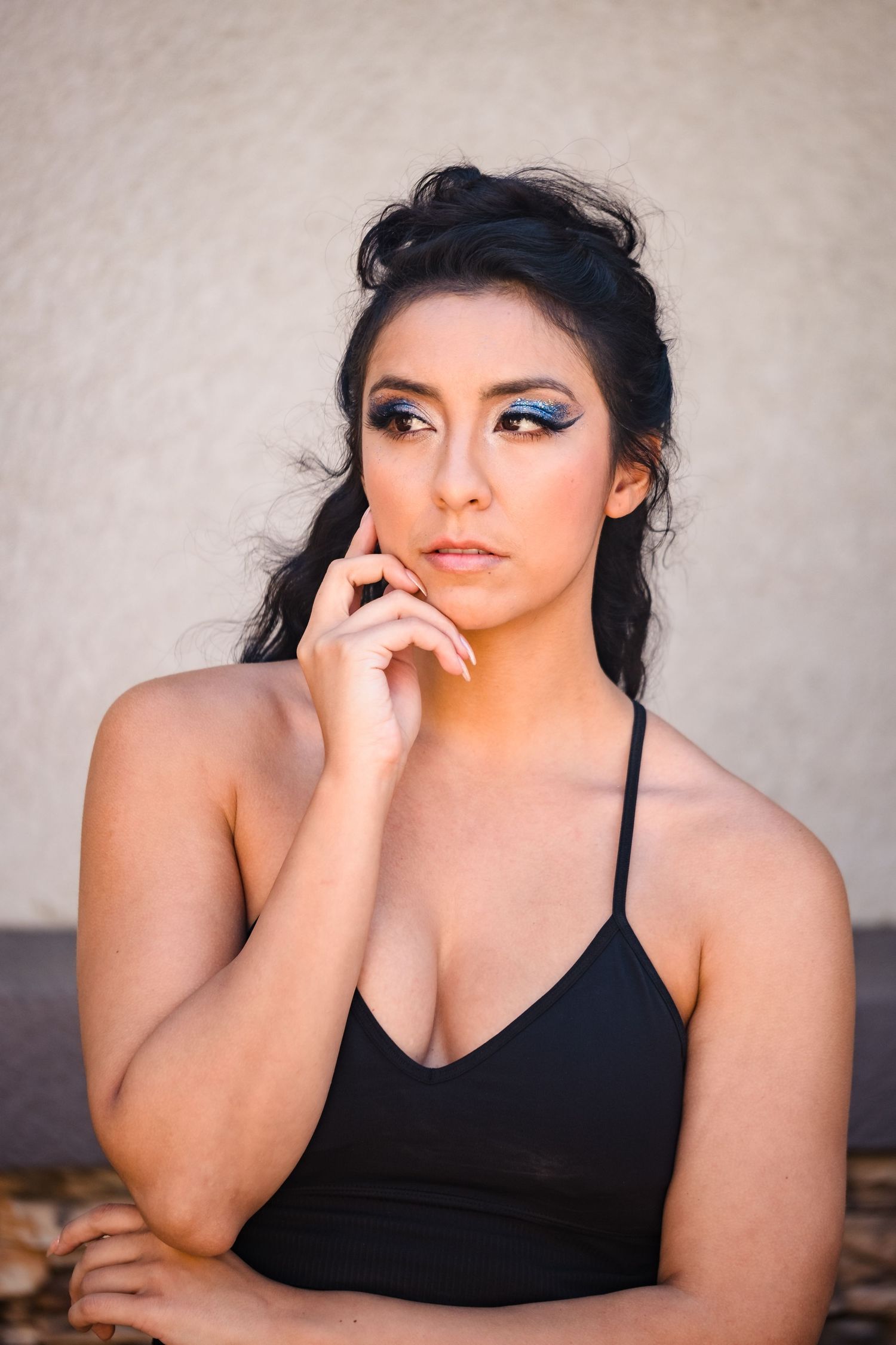 A series of artistic portrait photos showing a person in a black top against a neutral background posing thoughtfully.