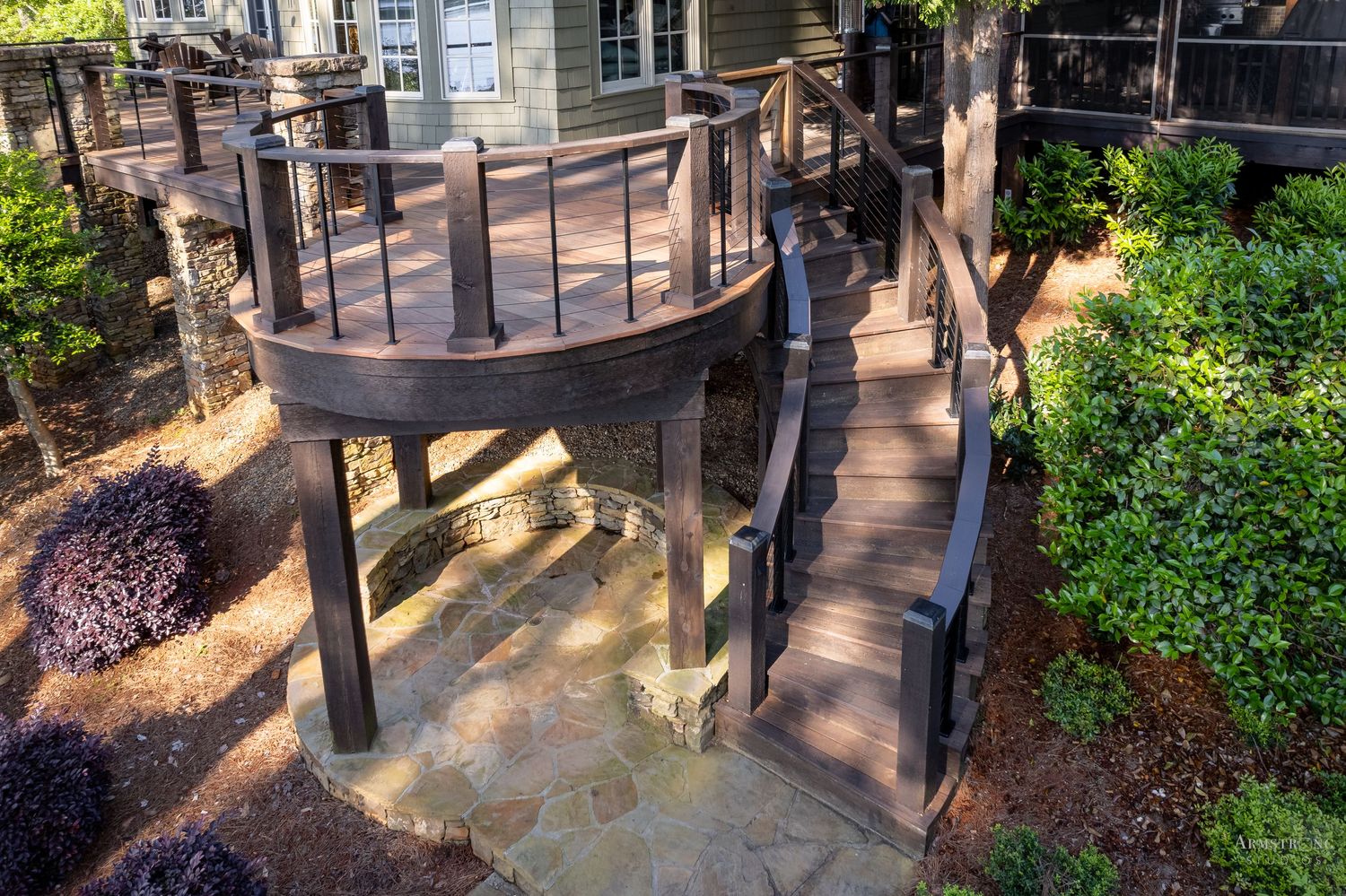 Sunlit garden pathway with decorative metal railings and lush green landscaping creates a peaceful outdoor walkway.